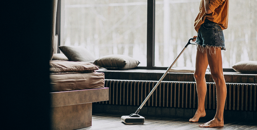 Woman vacuuming a clean living room, showing how everyday cleaning tasks promote a sense of control and emotional well-being.