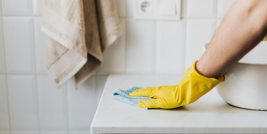 Angelic Maids professional cleaning a bathroom sink, demonstrating how cleaning services work in Boca Raton with thorough and effective results.