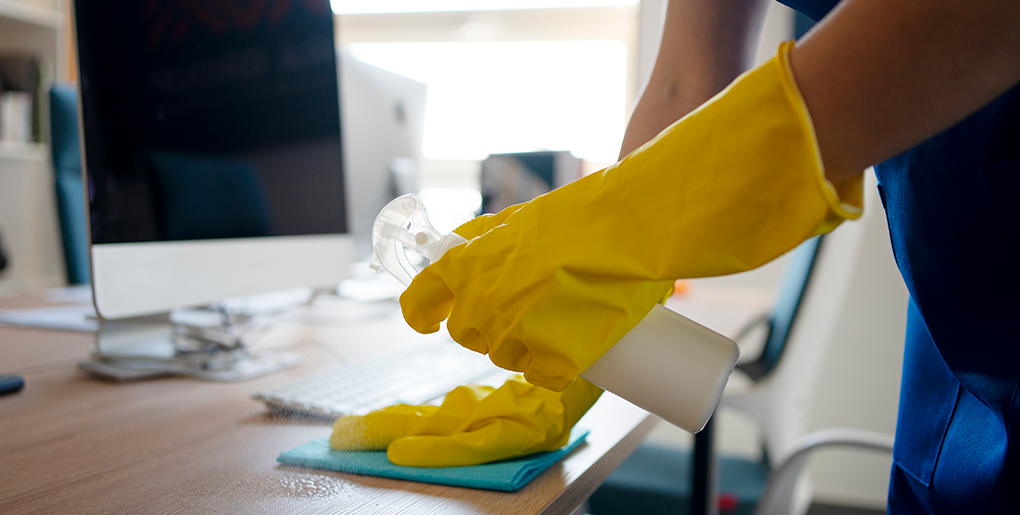 Angelic Maids employee cleaning a desk in a home office in Boca Raton
