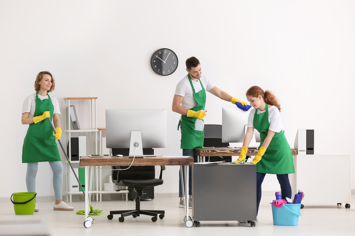 Team of young cleaning service professionals at work in office