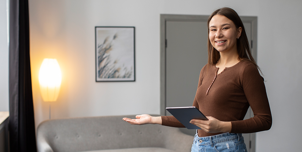 Woman holding a tablet displaying a home, representing Airbnb preparation with Boca Raton cleaning services